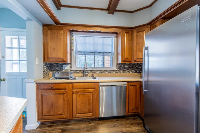 a kitchen with stainless steel appliances granite countertop a sink and a refrigerator