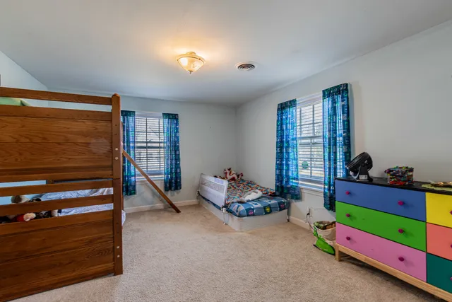a bedroom with bunk beds and a dresser in it