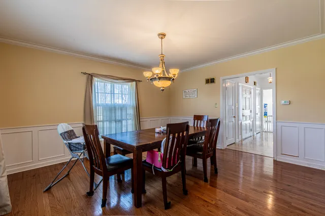 a dining room with furniture window and wooden floor