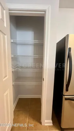 a view of walk in closet with empty racks