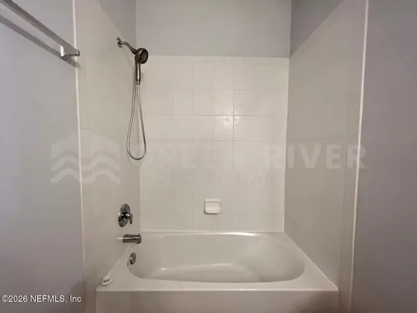 a white bath tub sitting next to a shower