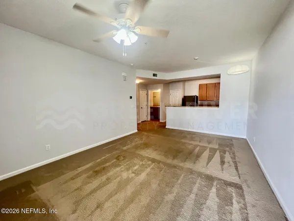 a view of an empty room with a chandelier fan