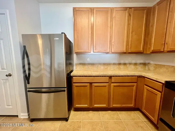 a kitchen with a refrigerator and cabinets