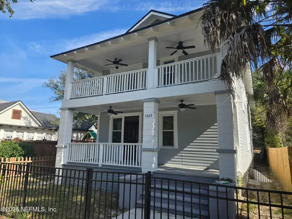 a view of a brick house with wooden fence