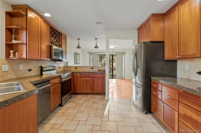 a kitchen with stainless steel appliances granite countertop a refrigerator stove and sink