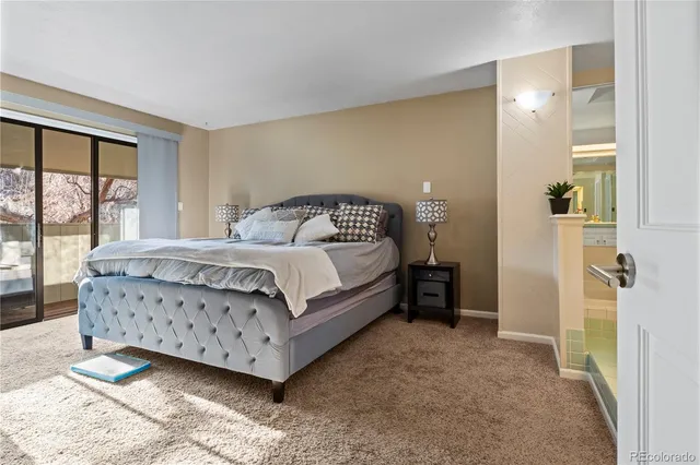 a bedroom with a bed lamp and a large window