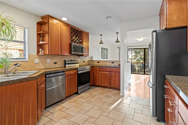 a kitchen with stainless steel appliances granite countertop a sink stove and refrigerator
