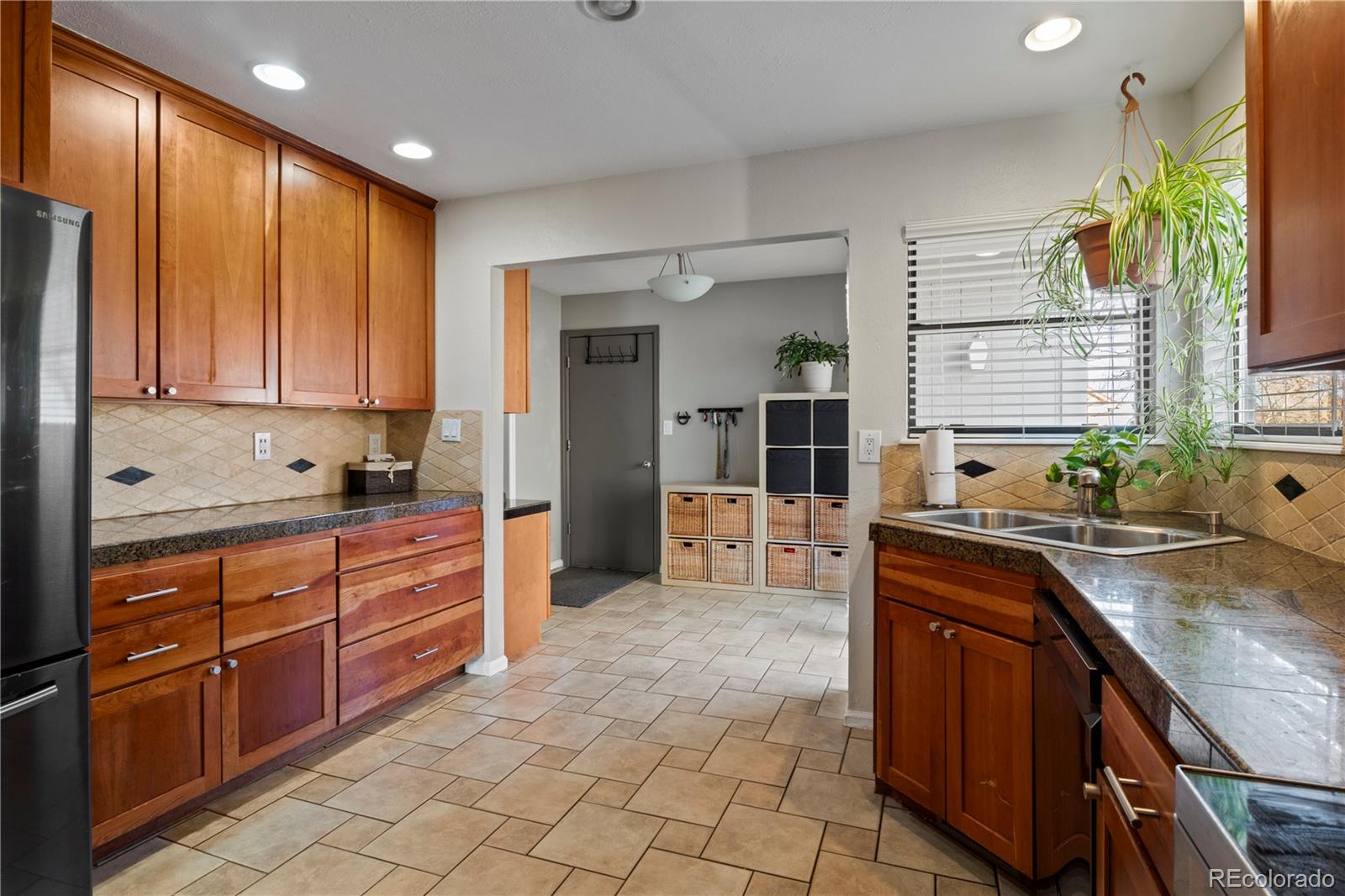 15780 Sandtrap Way Morrison, CO 80465 - Photo 10 of 36 a large kitchen with kitchen island granite countertop a sink counter space and cabinets