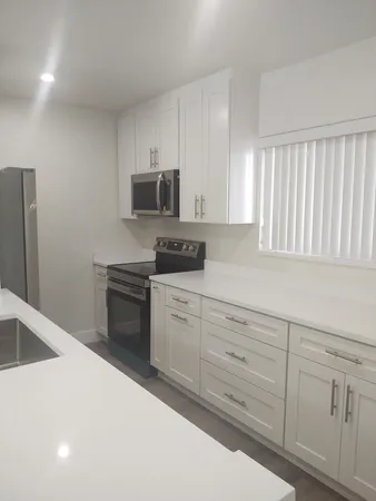 a kitchen with white cabinets and stainless steel appliances