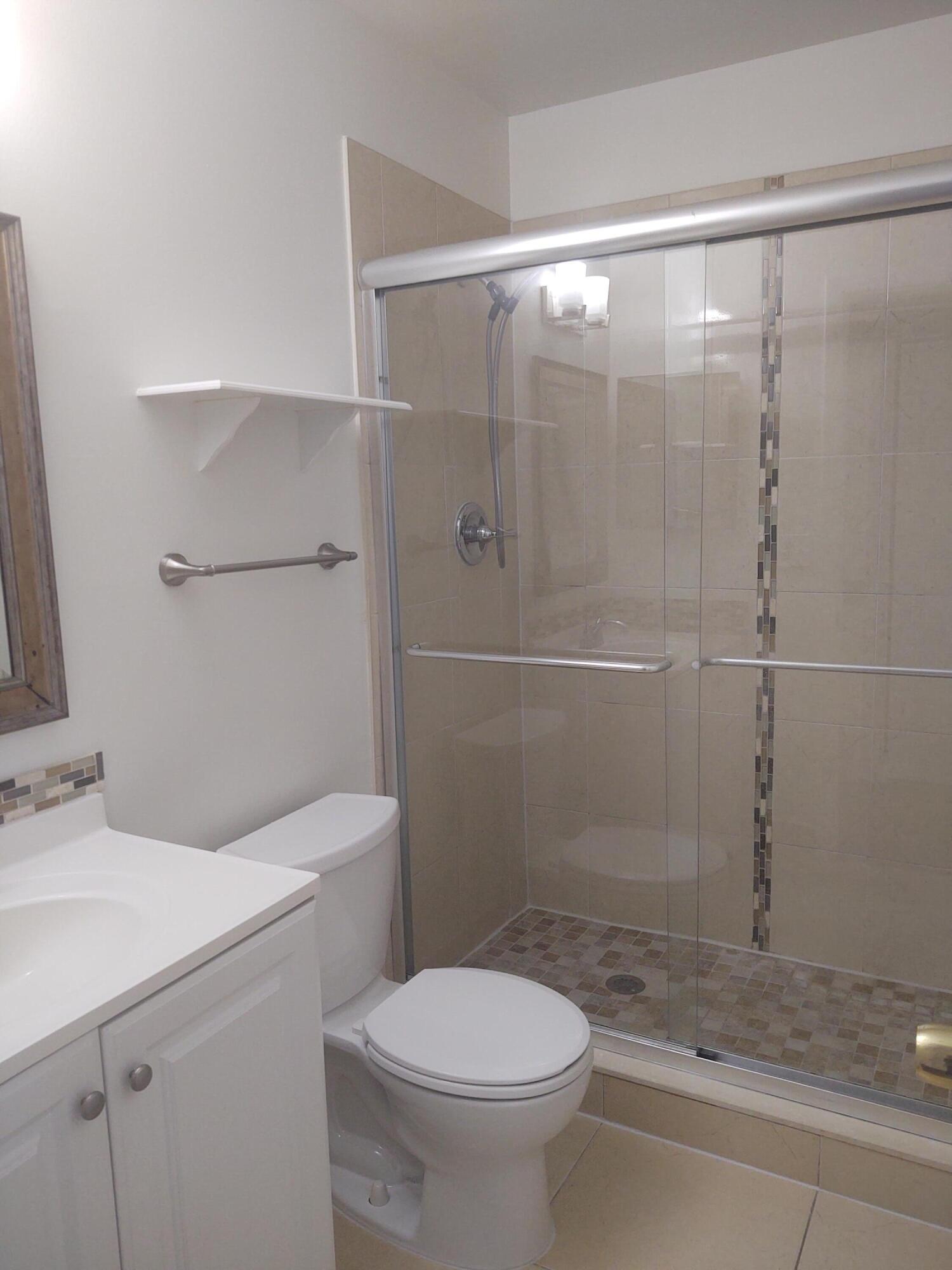 140 Northwest 70th Street, Unit 2040 Boca Raton, FL 33487 - Photo 11 of 18 a bathroom with a shower a toilet and sink