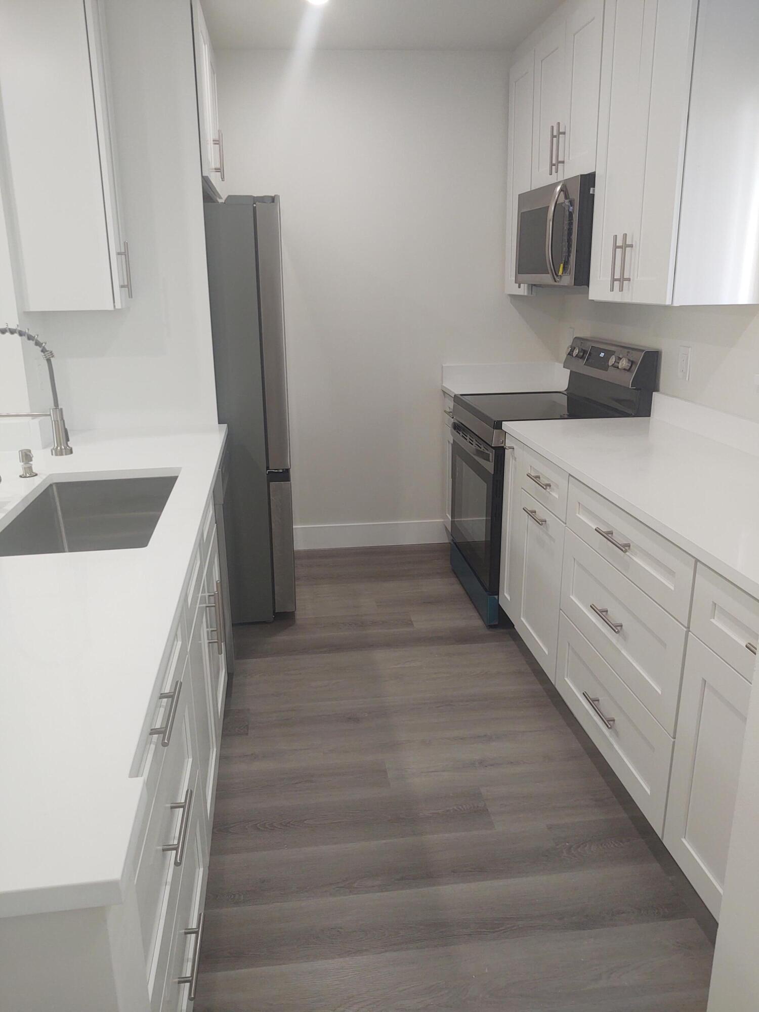 140 Northwest 70th Street, Unit 2040 Boca Raton, FL 33487 - Photo 3 of 18 a kitchen with a sink and refrigerator