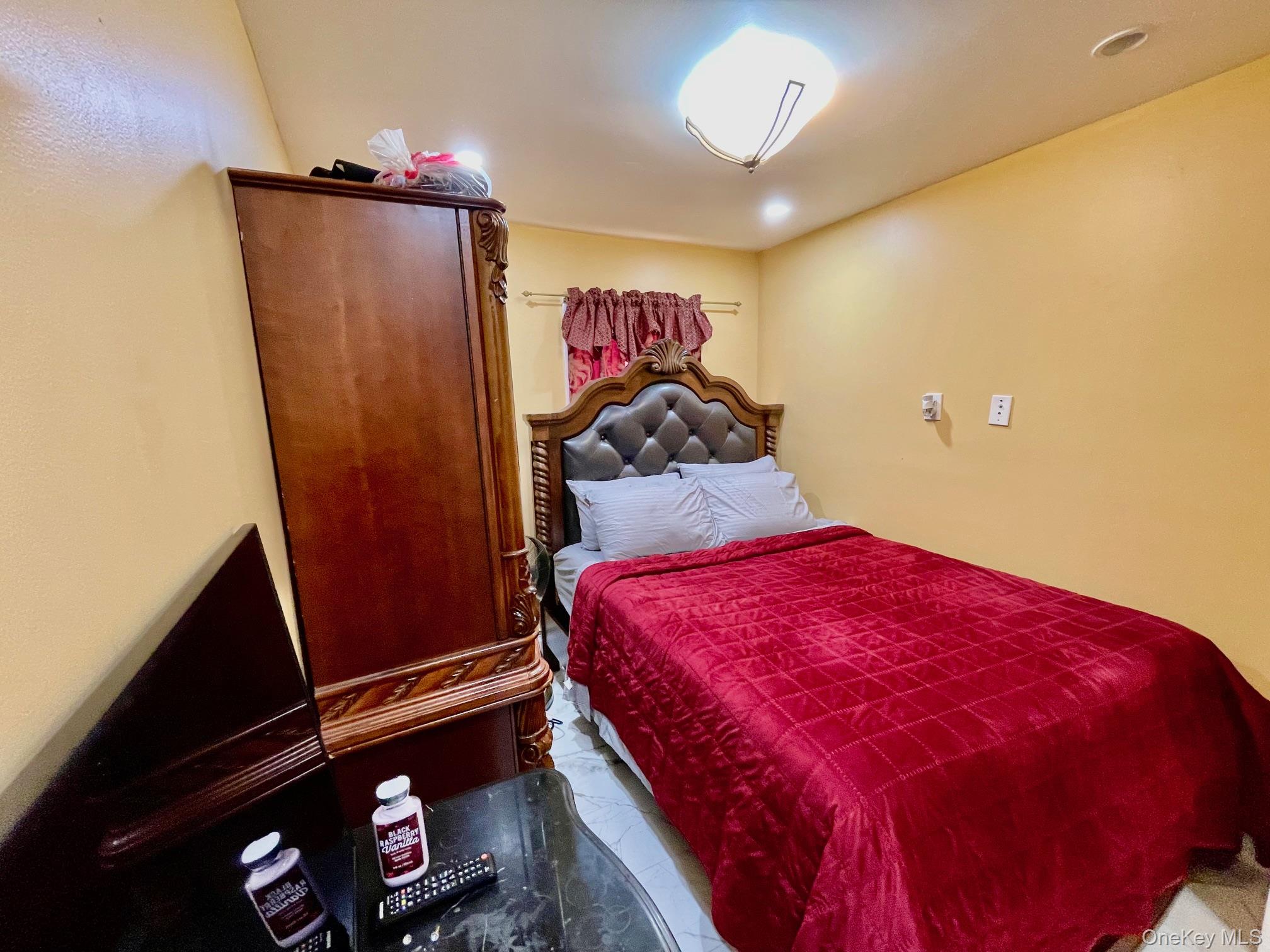 102-03 Rau Court Queens, NY 11414 - Photo 5 of 12 a bedroom with a bed and a mirror