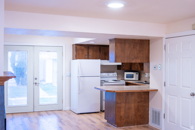 1269 North 400 East, Unit 3 Logan, UT 84341 - Photo 9 of 23 Kitchenette featuring wood-finish cabinetry, white appliances, and a breakfast bar