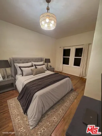 a bedroom with a large bed and a chandelier