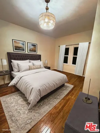 a bedroom with a large bed and a chandelier