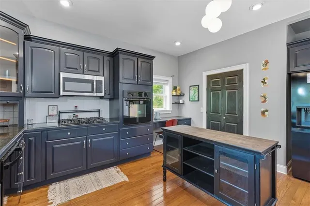 a kitchen with stainless steel appliances granite countertop wooden cabinets a stove top oven a sink and dishwasher