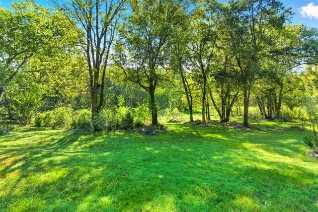 an aerial view of a residential houses with outdoor space and lake view
