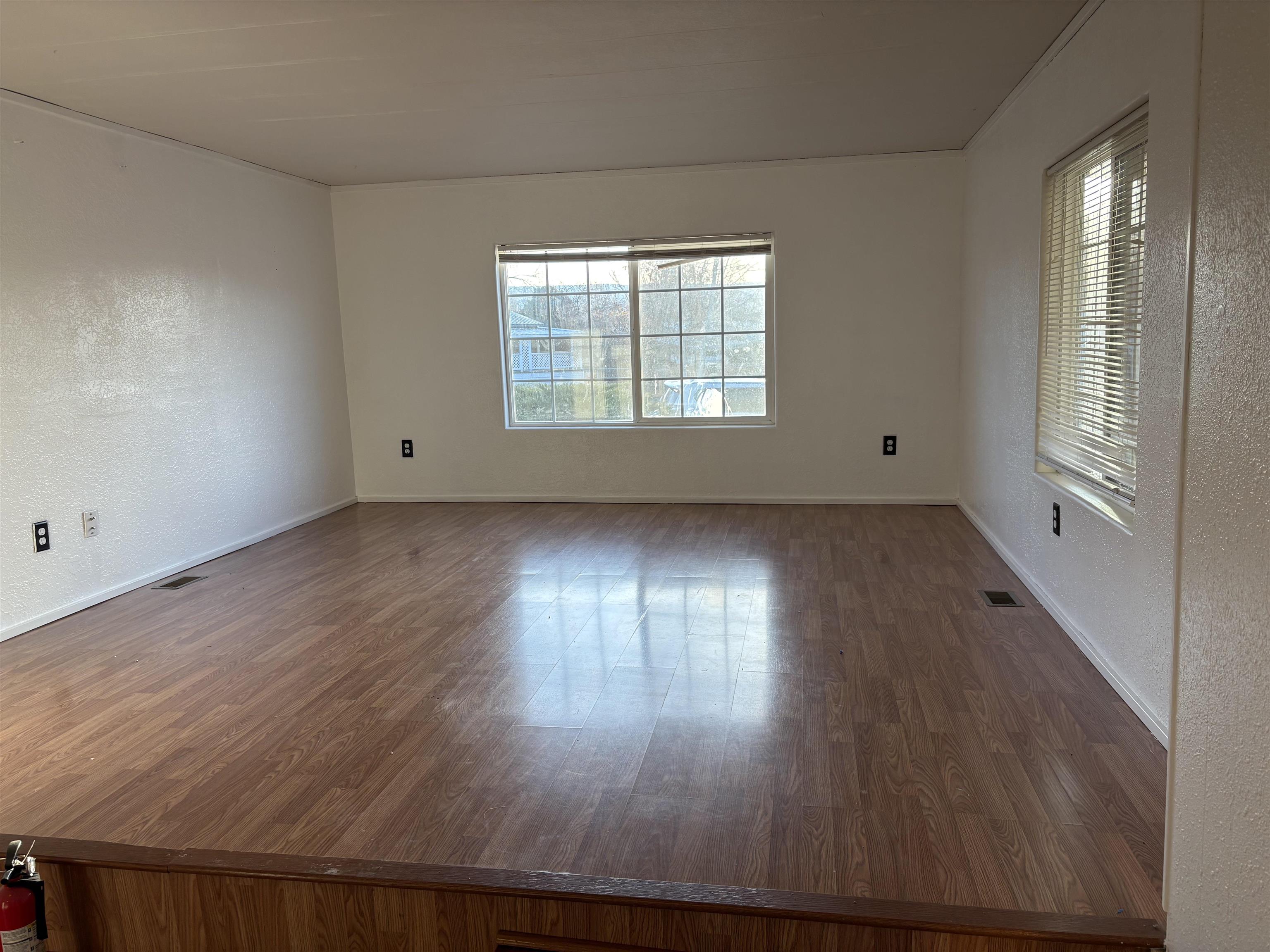 532 Centennial Road Grand Junction, CO 81504 - Photo 5 of 18 an empty room with wooden floor and windows