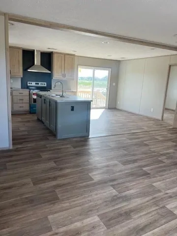 a kitchen with stainless steel appliances wooden floor and a refrigerator