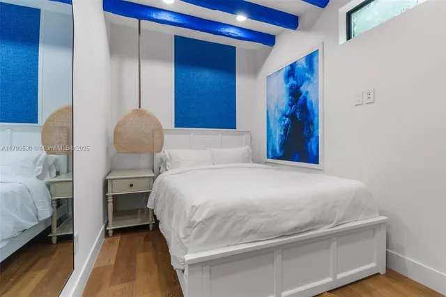 a bedroom with a large bed and a painting on the wall