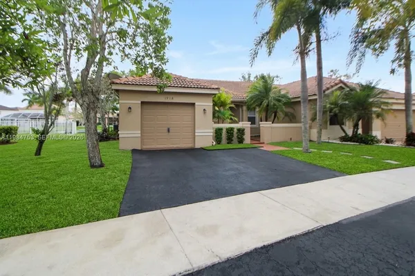a view of a house with a yard and palm trees
