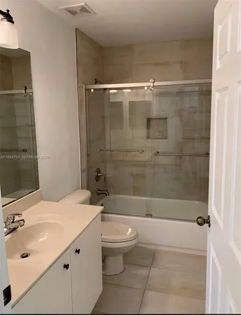 a bathroom with a bathtub shower sink mirror and toilet