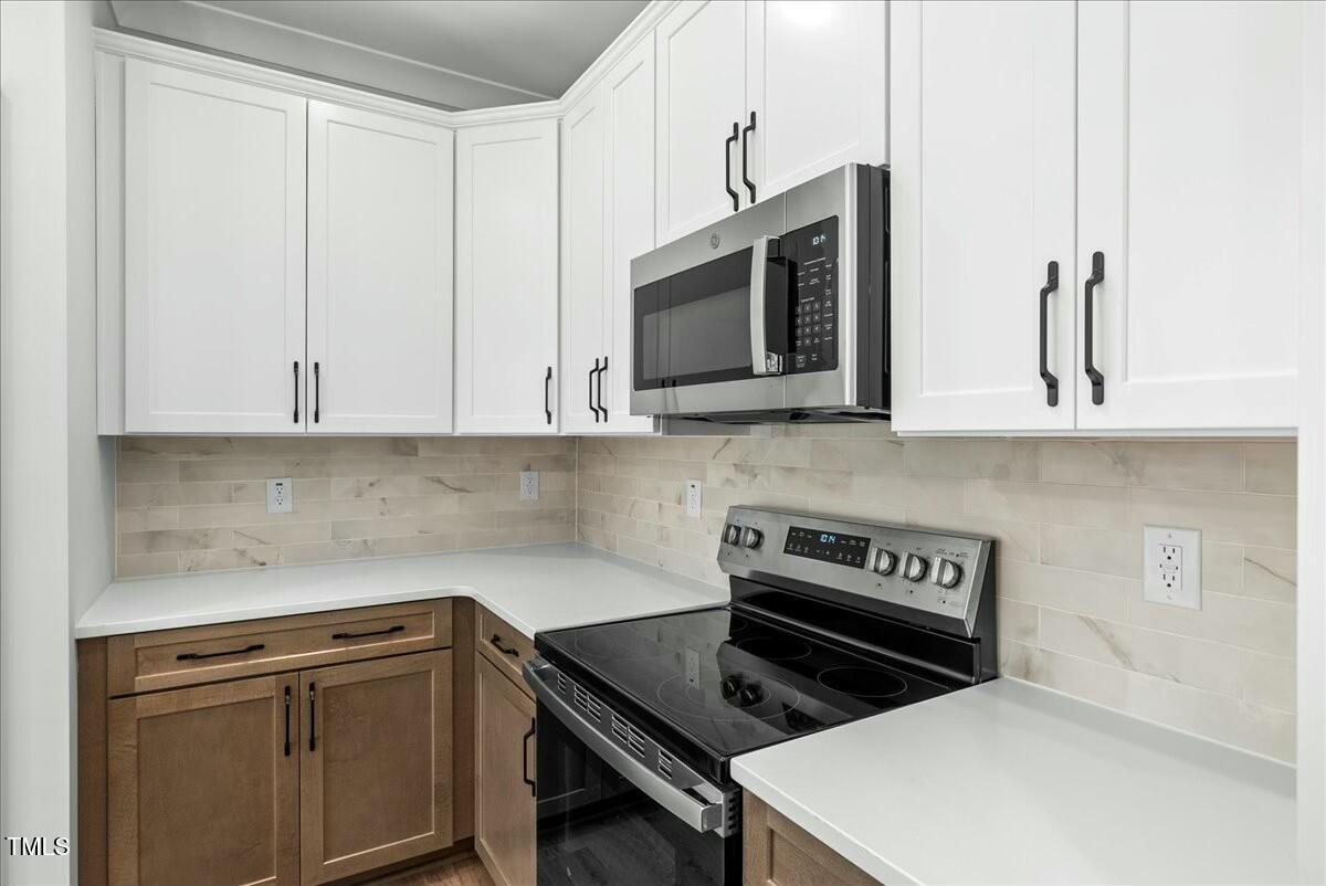 109 Averly Court Stem, NC 27581 - Photo 11 of 36 a kitchen with stainless steel appliances a stove a microwave and cabinets