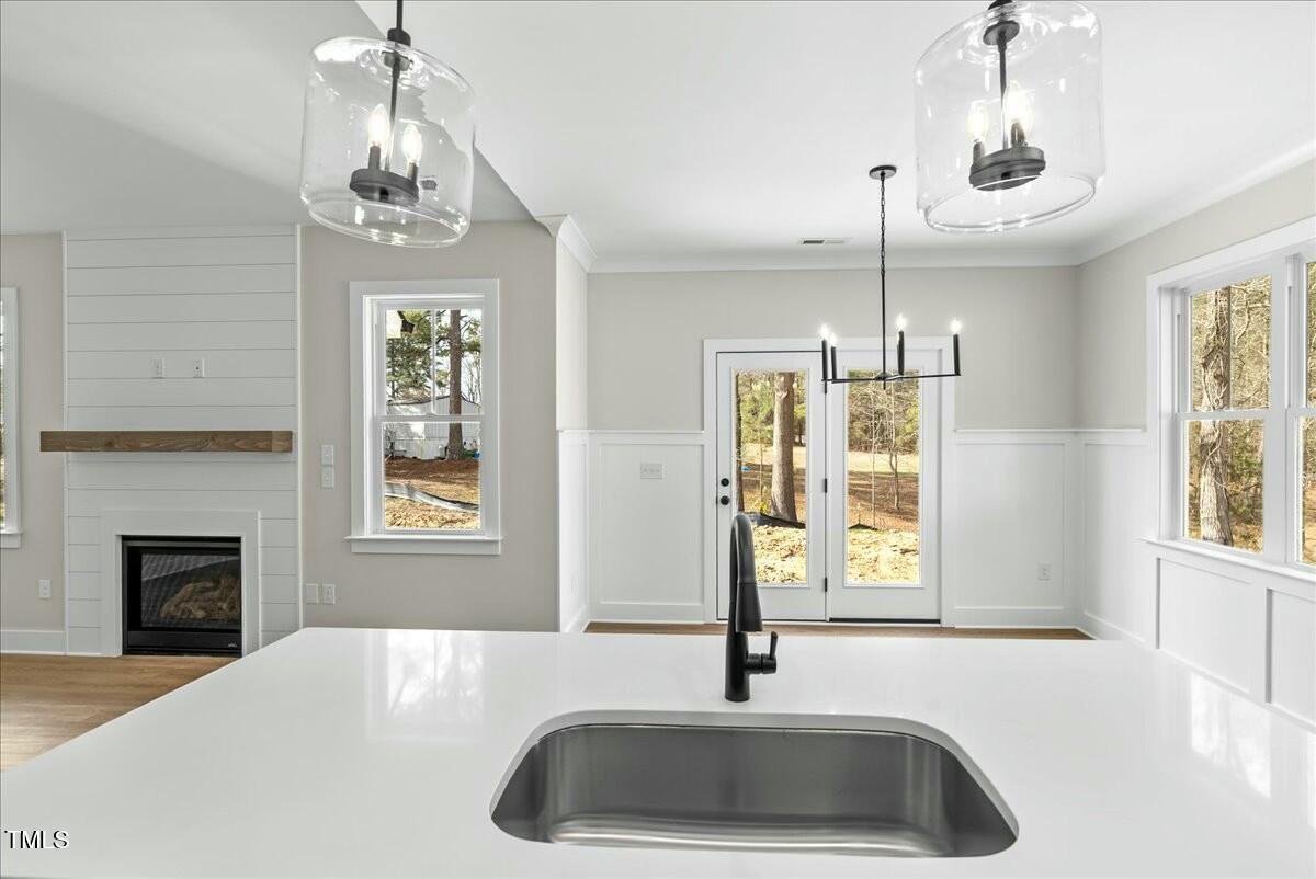 109 Averly Court Stem, NC 27581 - Photo 12 of 36 a kitchen with a sink chandelier and fireplace