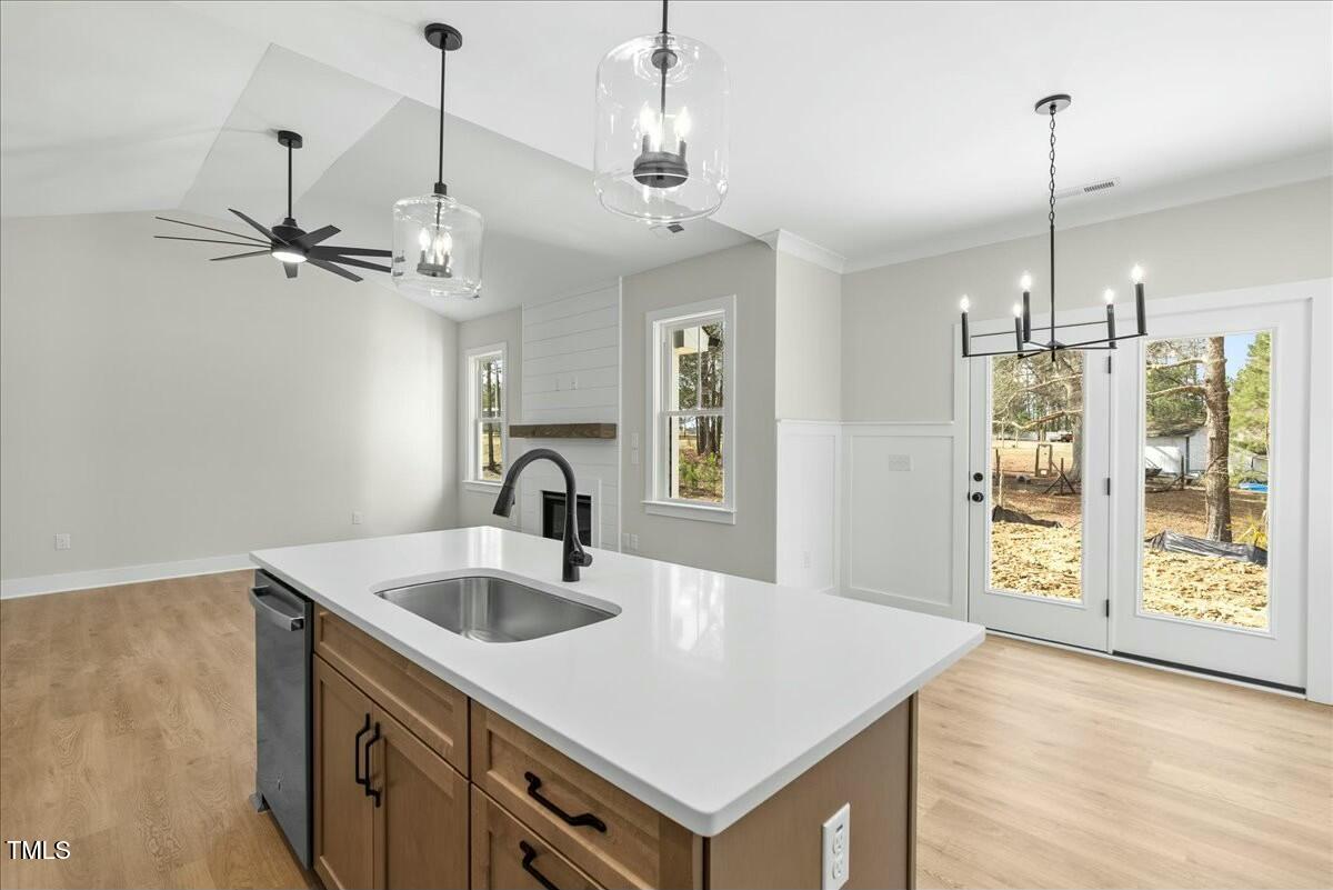 109 Averly Court Stem, NC 27581 - Photo 13 of 36 a kitchen with a sink a center island a stove and a wooden floor