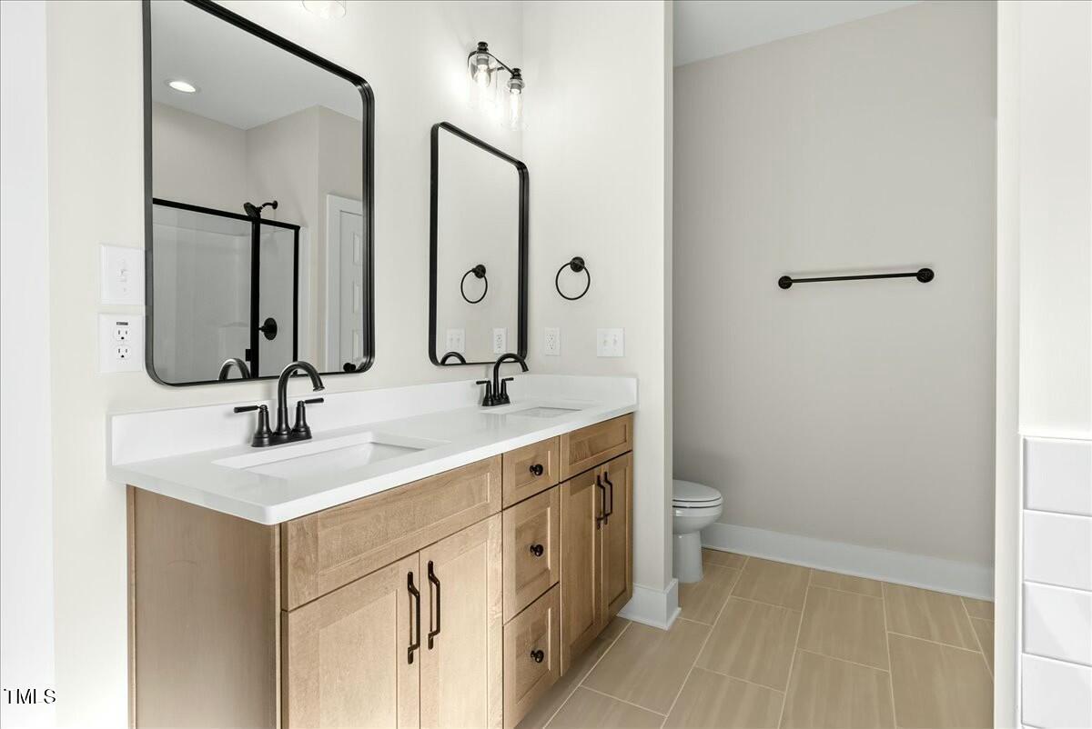 109 Averly Court Stem, NC 27581 - Photo 26 of 36 a bathroom with a double vanity sink toilet and mirror