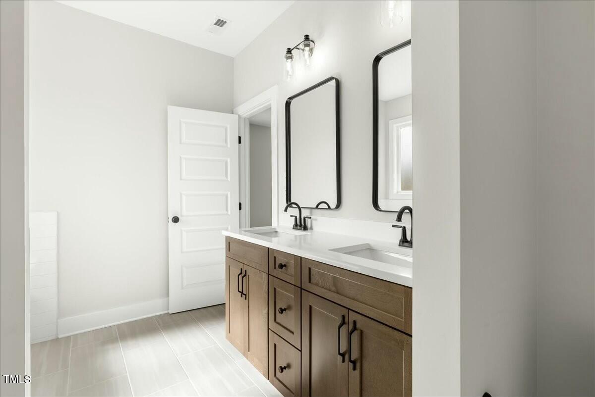 109 Averly Court Stem, NC 27581 - Photo 27 of 36 a bathroom with a double vanity sink mirror and
