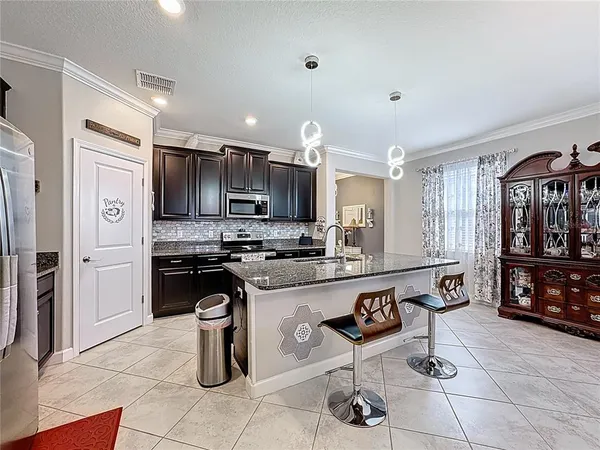 a kitchen with stainless steel appliances granite countertop a sink stove microwave and refrigerator