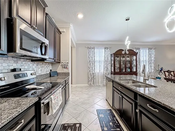 a kitchen with stainless steel appliances kitchen island granite countertop a stove and a refrigerator