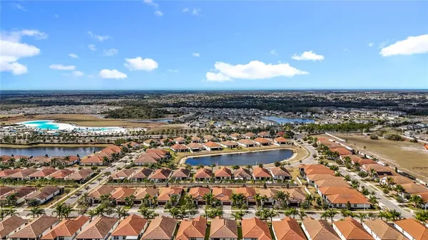 an aerial view of residential houses with outdoor space and trees