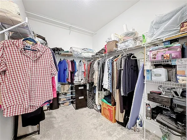 a view of walk in closet with clothes and shoes