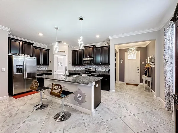 a kitchen with stainless steel appliances granite countertop a refrigerator and a stove top oven