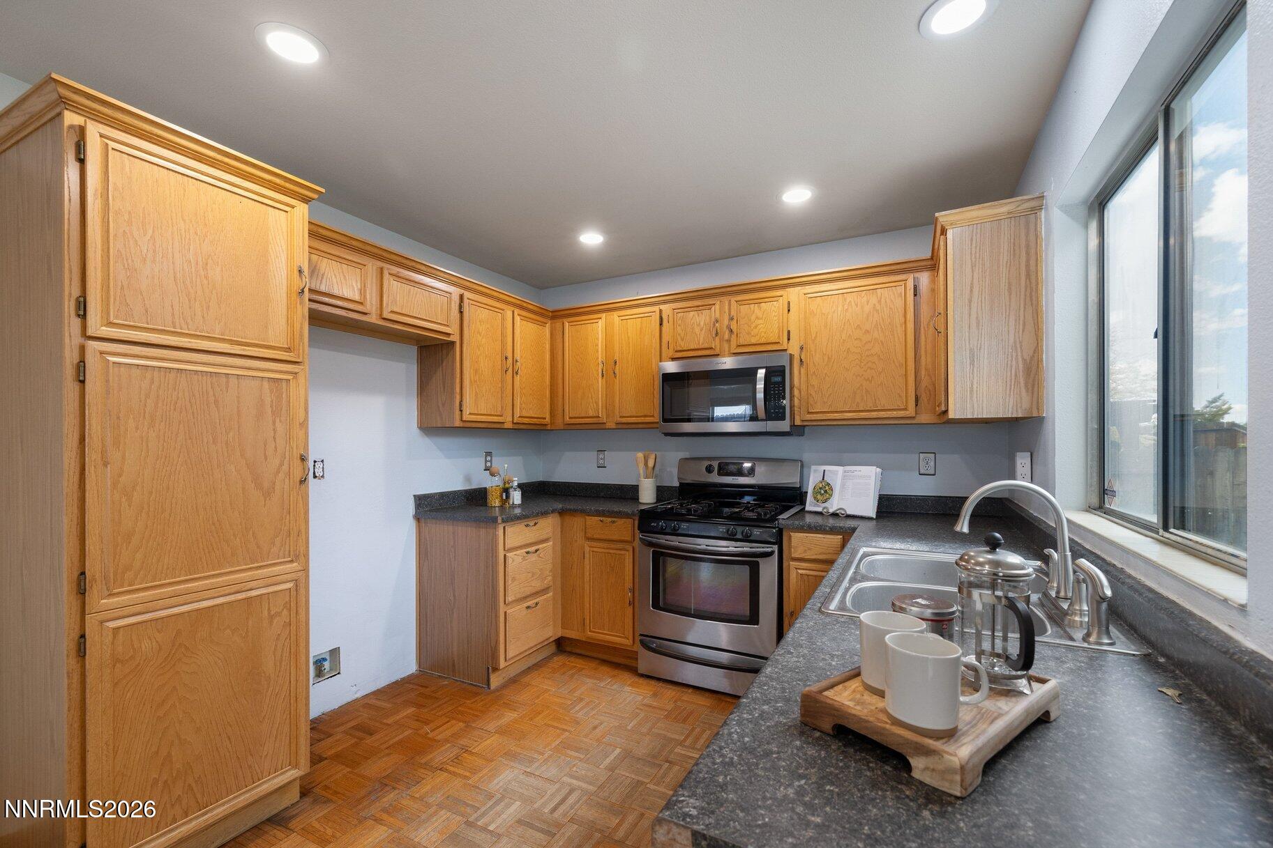 8486 Piper Place Reno, NV 89506 - Photo 13 of 80 a kitchen with stainless steel appliances granite countertop a refrigerator stove and sink