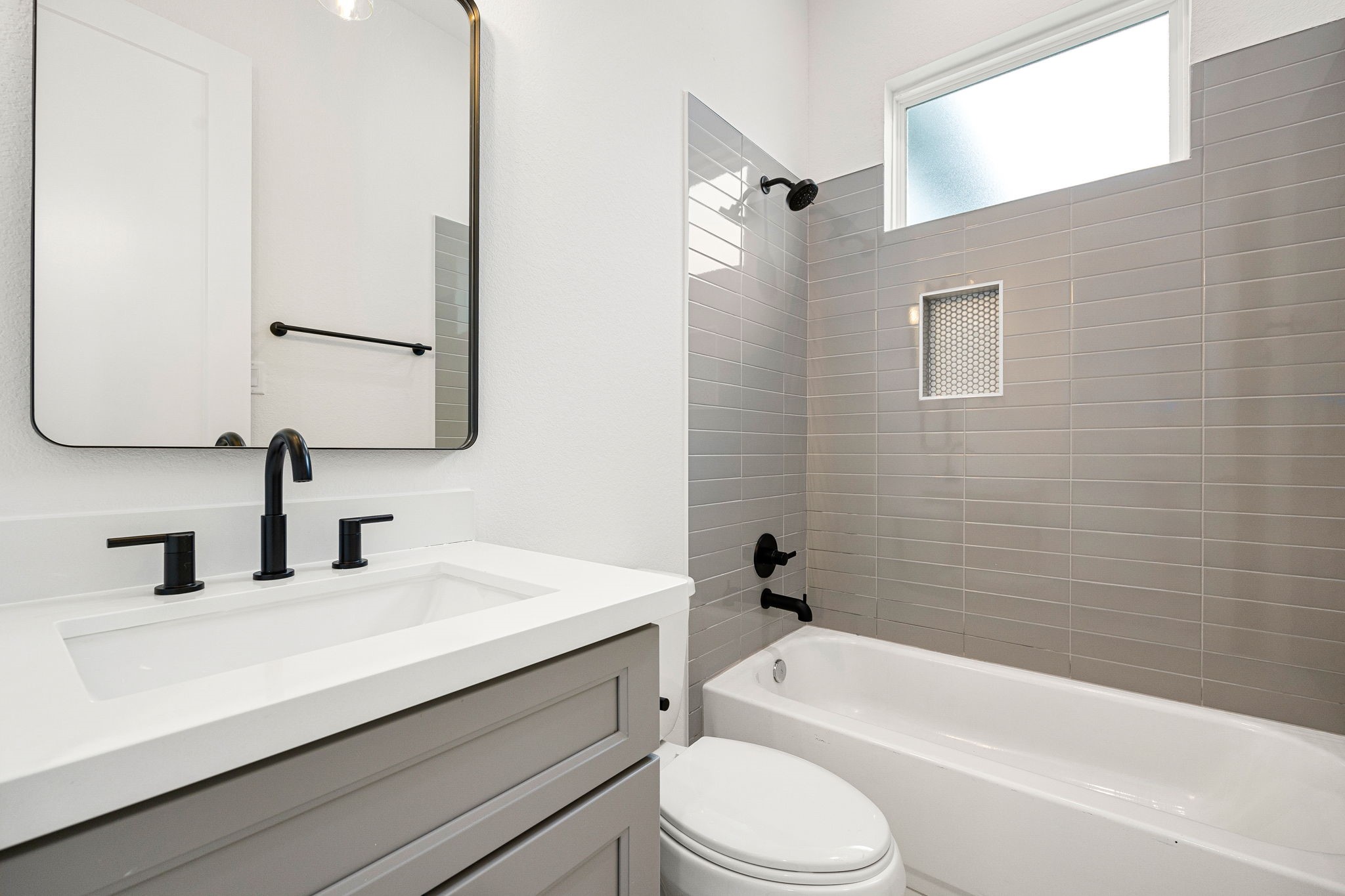 747 Dumble Street Houston, TX 77023 - Photo 13 of 18 a bathroom with a sink a toilet a mirror a bathtub and shower