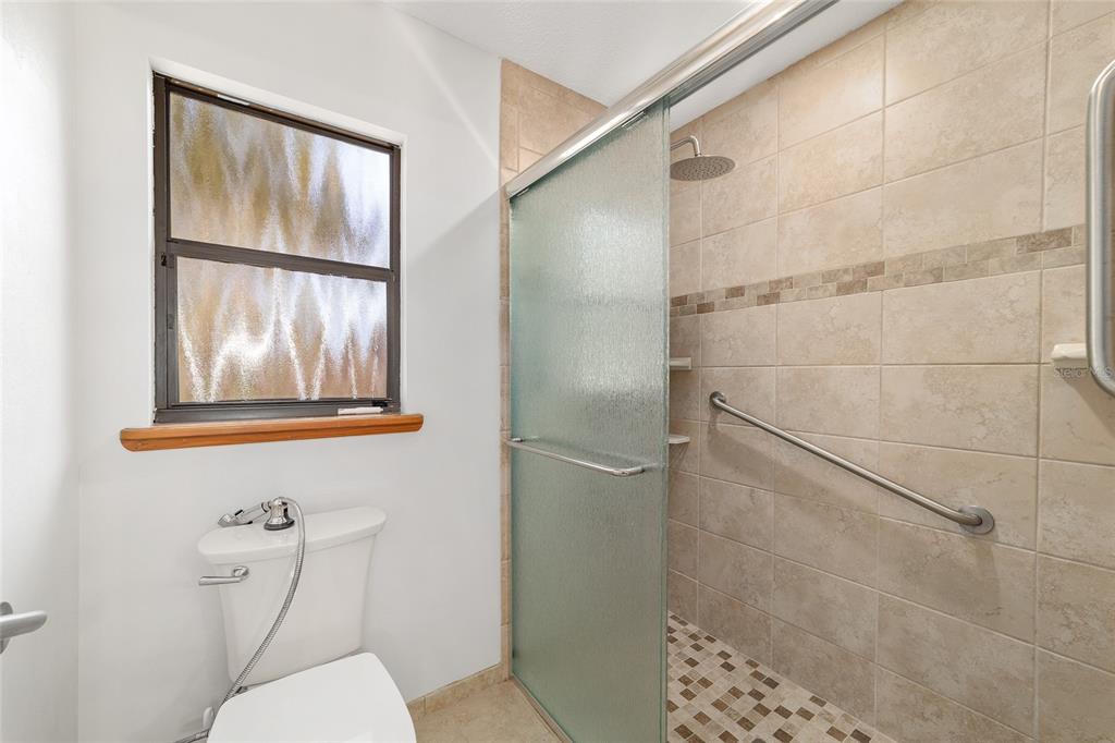 2416 Southeast 15th Street Ocala, FL 34471 - Photo 53 of 98 a bathroom with a window and a shower