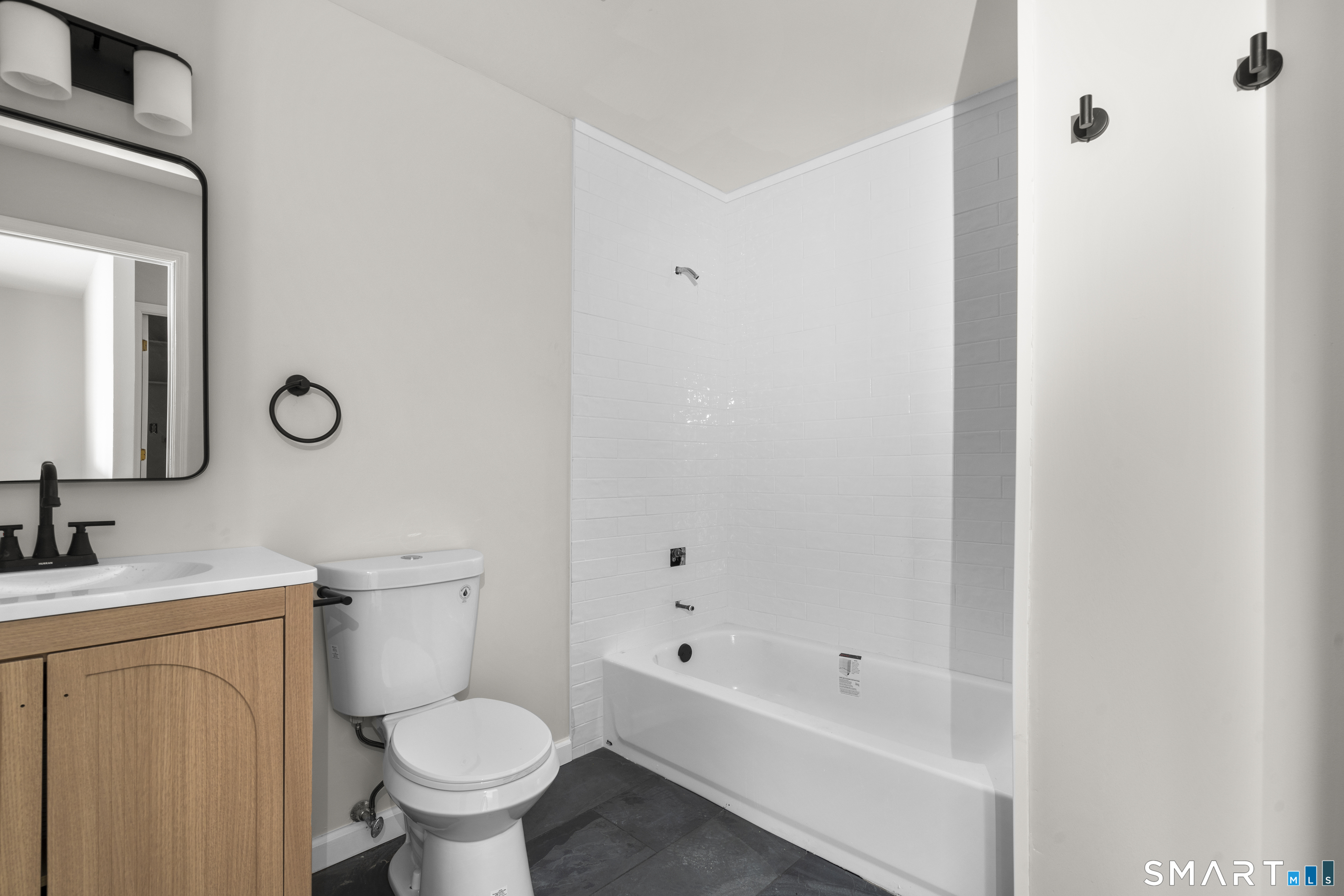 201 College Street, Unit 5 Middletown, CT 06457 - Photo 14 of 30 a bathroom with a toilet sink and mirror