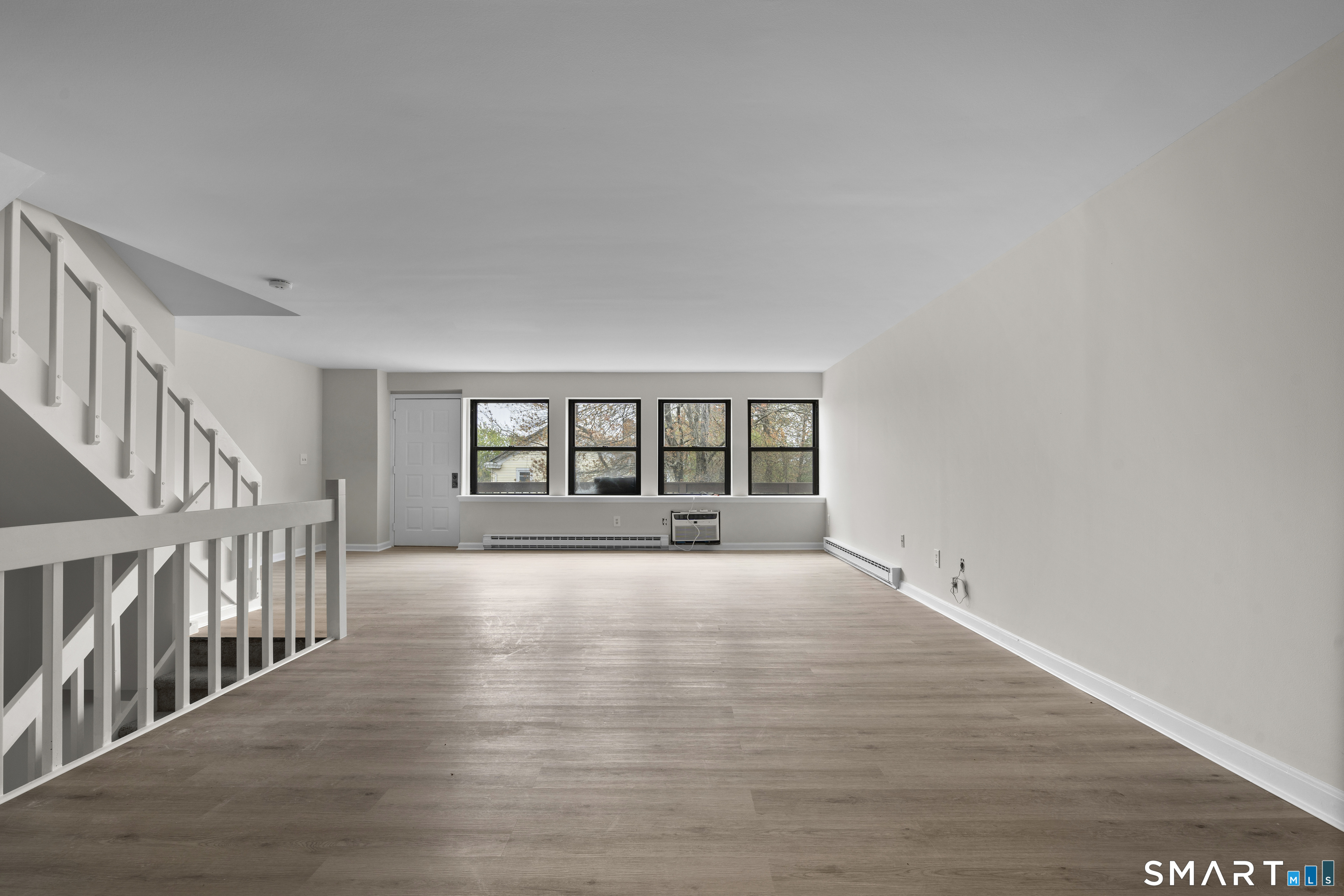 201 College Street, Unit 5 Middletown, CT 06457 - Photo 7 of 30 a view of an empty room with wooden floor and a window