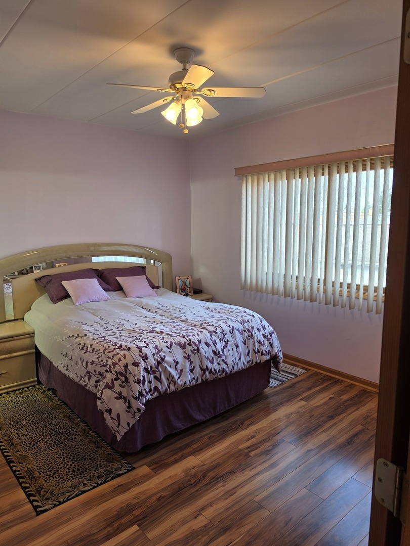 7902 Nagle Avenue, Unit 2S Burbank, IL 60459 - Photo 13 of 24 a bedroom with a bed and a chandelier