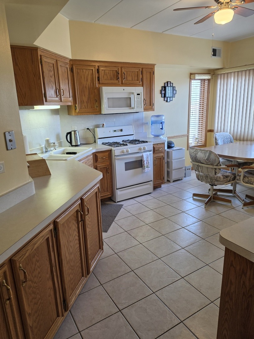 7902 Nagle Avenue, Unit 2S Burbank, IL 60459 - Photo 9 of 24 a kitchen with a sink cabinets and window