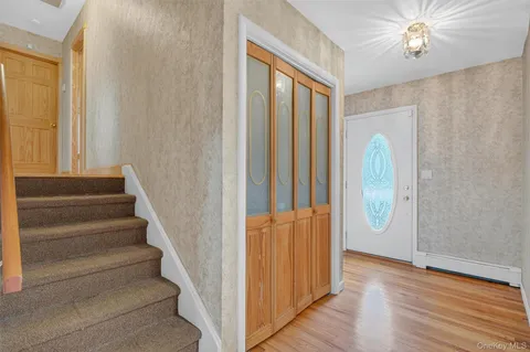 a view of a hallway with wooden floor and staircase