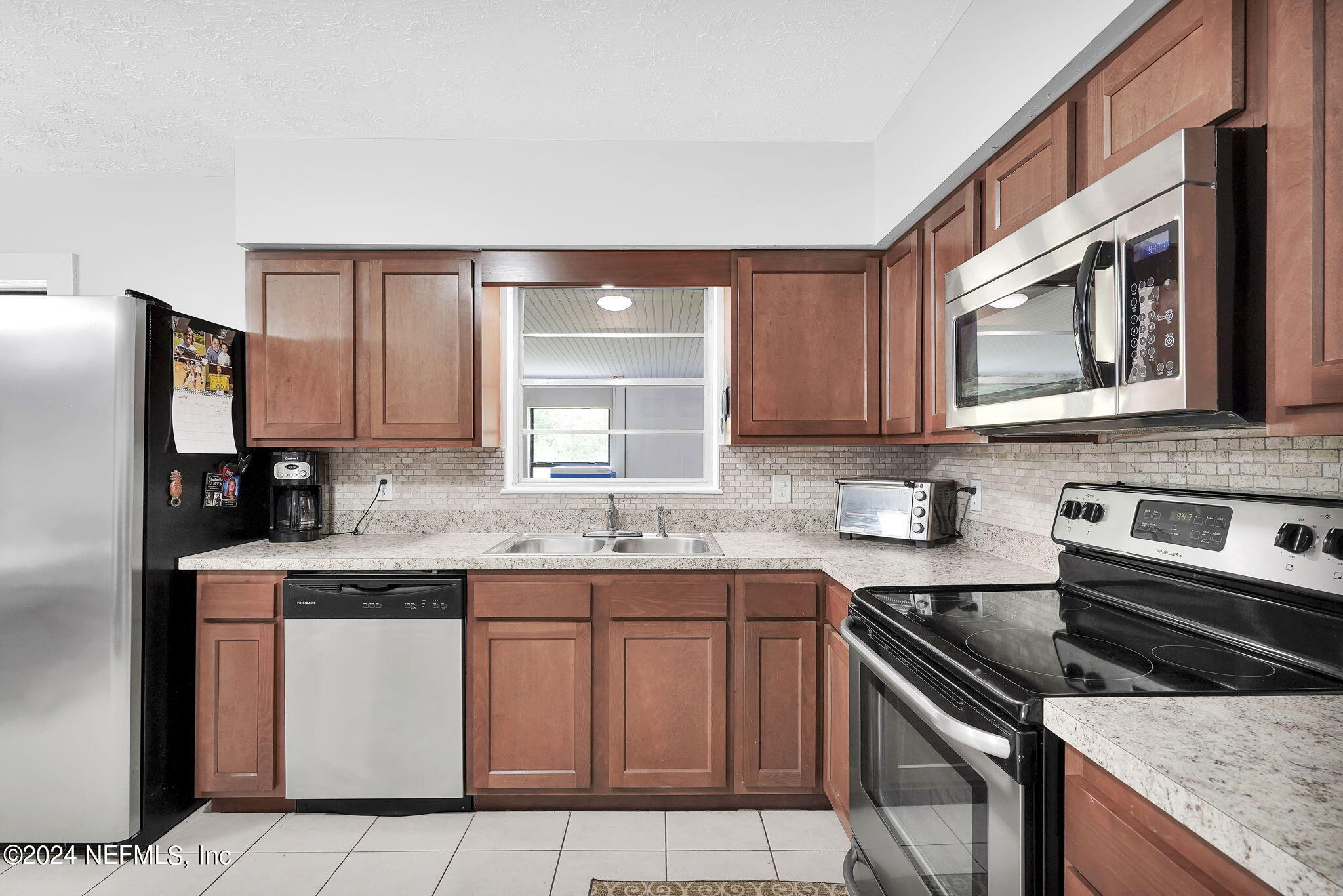 54371 Hazel Jones Road Callahan, FL 32011 - Photo 13 of 36 a kitchen with stainless steel appliances granite countertop a stove a sink dishwasher and a refrigerator