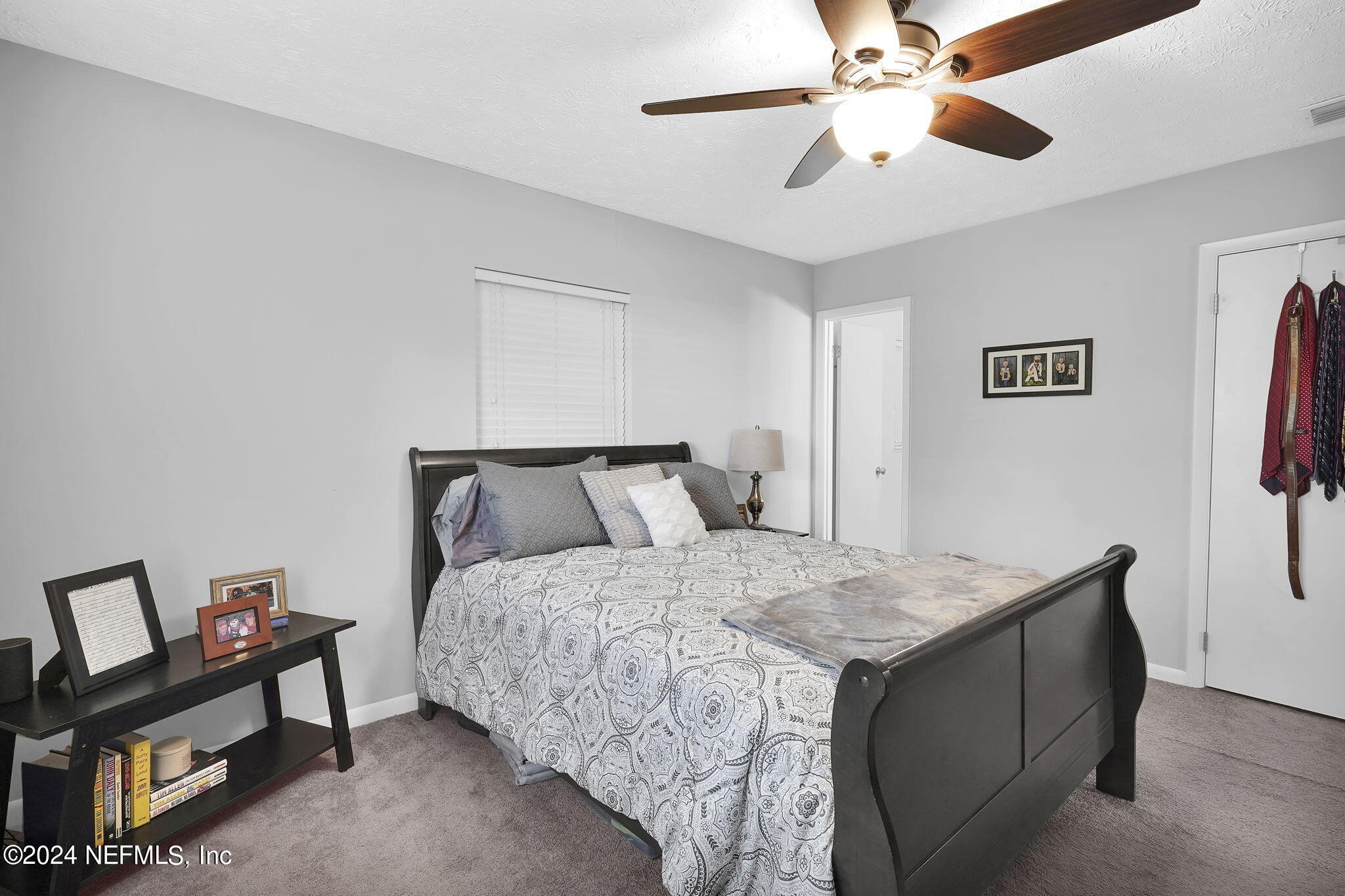 54371 Hazel Jones Road Callahan, FL 32011 - Photo 24 of 36 a bedroom with a bed and a chandelier