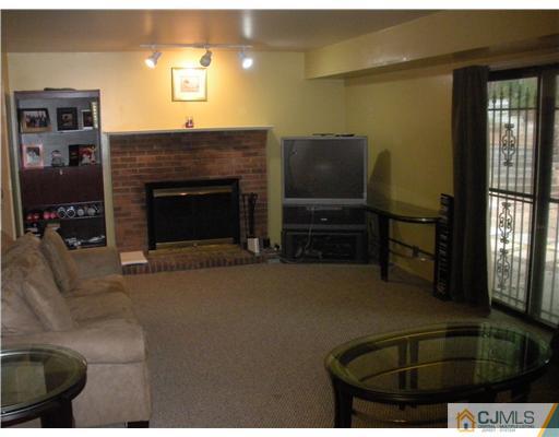 36 Brookside Road Edison, NJ 08817 - Photo 8 of 19 a living room with furniture a flat screen tv and a fireplace