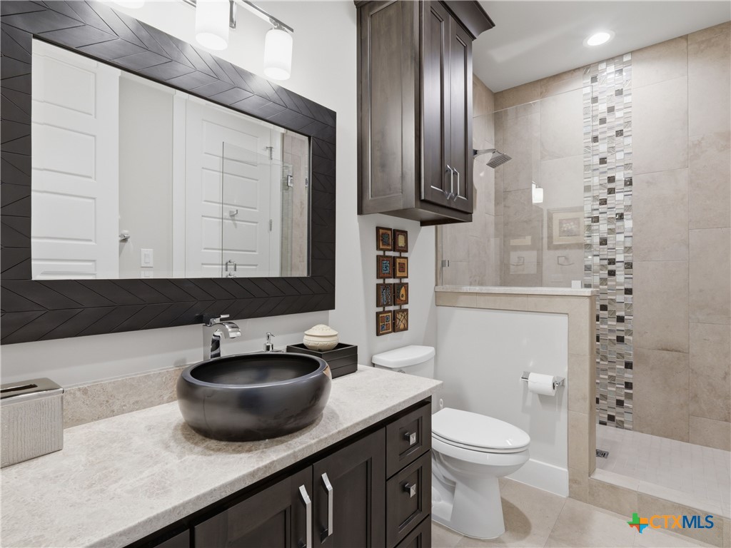 5913 Verden Ridge New Braunfels, TX 78132 - Photo 24 of 48 a bathroom with a sink a toilet and shower