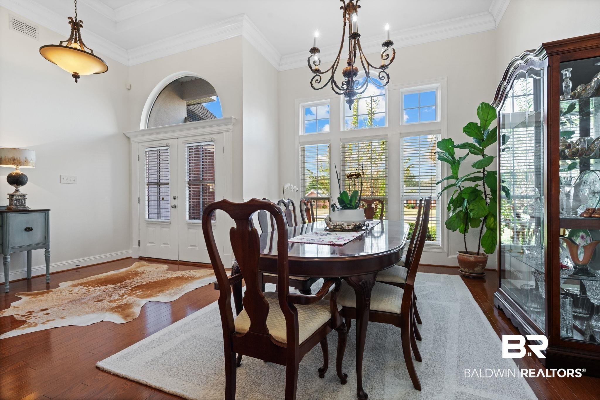 4771 Pecan Ridge East Mobile, AL 36619 - Photo 15 of 48 Dining area featuring french doors, dark wood-style flooring, ornamental molding, a chandelier, and a high ceiling