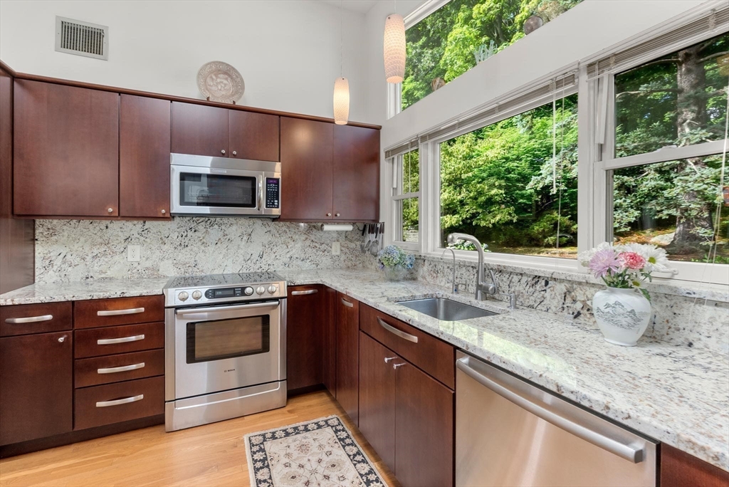 54 Clark Street Newton, MA 02459 - Photo 12 of 34 a kitchen with stainless steel appliances kitchen island granite countertop a sink and a stove